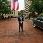 Hampden District Attorney Anthony Gulluni stands outside underneath an American flag.