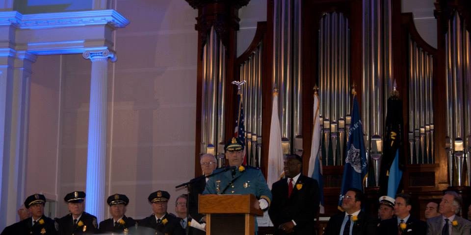 A police officer speaks at a podium during an event.