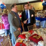 Hampden District Attorney Anthony Gulluni talks with someone as they stand at an event.