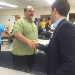 Hampden District Attorney Anthony Gulluni shakes hands with a person.