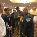 Hampden District Attorney Anthony Gulluni talks with three people at an event.