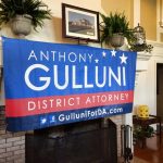 A mantle with a Hampden District Attorney Anthony Gulluni banner hanging from it.