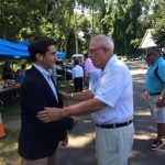 Hampden District Attorney Anthony Gulluni talks to a person at an outdoor event.