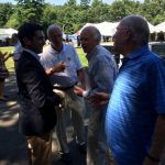 Hampden District Attorney Anthony Gulluni talks to three people at an outdoor event.