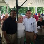 Hampden District Attorney Anthony Gulluni smiles and poses for a photo with two people.