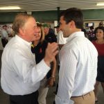 Hampden District Attorney Anthony Gulluni talks with people at an outdoor event.