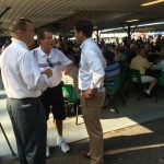 Hampden District Attorney Anthony Gulluni talks with two people at an outdoor event.