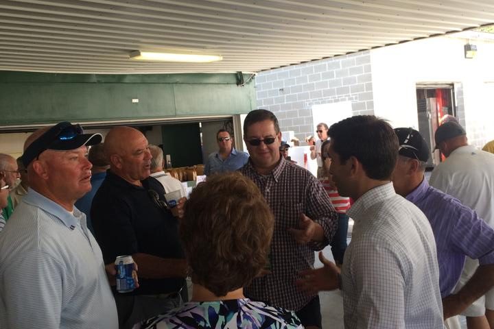 Hampden District Attorney Anthony Gulluni talks with a group of people at an event.