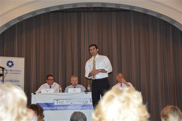 Hampden District Attorney Anthony Gulluni talks as he stands on a stage.