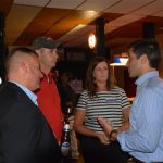 Hampden District Attorney Anthony Gulluni talks with three people at an event.