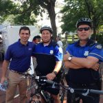 Hampden District Attorney Anthony Gulluni poses for a photo with two police officers on bicycles.