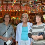 Three people smile and pose for a photo.