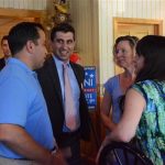 Hampden District Attorney Anthony Gulluni talks to three other people at an event.