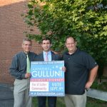 Hampden District Attorney Anthony Gulluni and two others pose with a campaign sign.