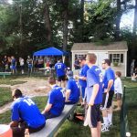 A team sits on the bench at a wiffle ball tournament.