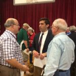 Hampden District Attorney Anthony Gulluni talks to two men at an event.