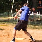 A person swinging a wiffle ball bat outside.