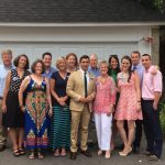 A group of people and Hampden District Attorney Anthony Gulluni stand in front of a garage and pose for a photo.