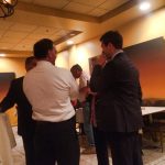 Hampden District Attorney Anthony Gulluni talks with at least two others at an event.