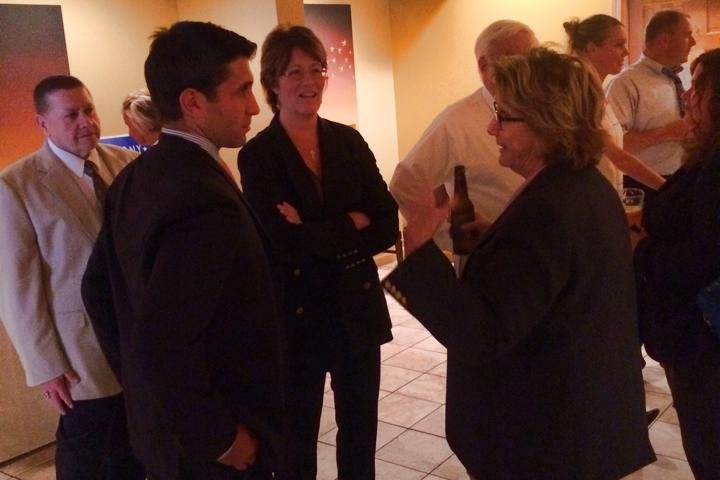 Hampden District Attorney Anthony Gulluni talks with at least two others at an event.