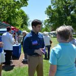 Hampden District Attorney Anthony Gulluni talks to two people at an outside event.