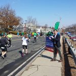 Hampden District Attorney Anthony Gulluni cheers on runners at a road race.