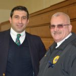 Hampden District Attorney Anthony Gulluni poses for a photo with a police officer.