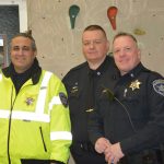 Three police officers smile and pose for a photo.
