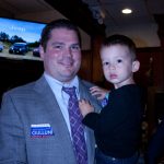 A man holds a little boy at an event in support of Hampden District Attorney Anthony Gulluni.