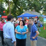 Hampden District Attorney Anthony Gulluni talks to two people at an outdoor event.