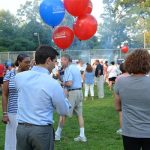 Hampden District Attorney Anthony Gulluni holds balloons at an outdoor event.