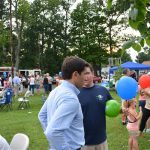 Hampden District Attorney Anthony Gulluni talks with a person at an outdoor event.