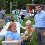 Hampden District Attorney Anthony Gulluni poses for a photo with two other people at an outdoor event.