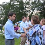Hampden District Attorney Anthony Gulluni shakes hands with a person at an outdoor event.