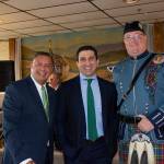 A man in a kilt stands with Hampden District Attorney Anthony Gulluni and another man in a suit.