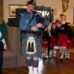 A man in a kilt playing the bagpipes.