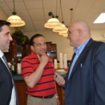 Hampden District Attorney Anthony Gulluni talks to two men.