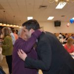 Hampden District Attorney Anthony Gulluni receives a hug from a woman in a purple sweater at a campaign event.
