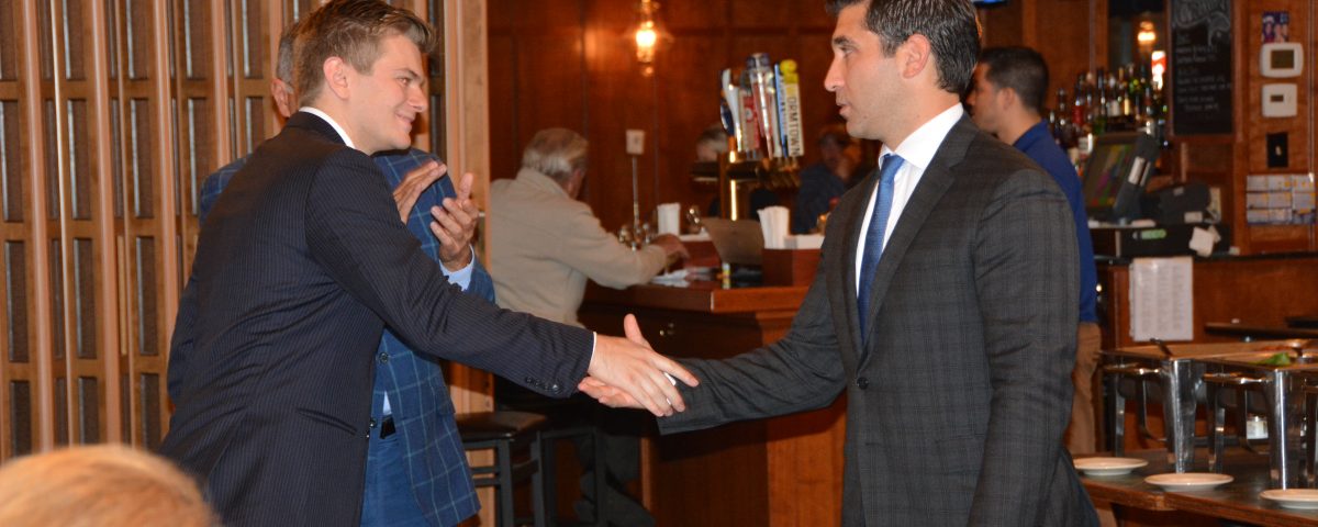 Hampden District Attorney Anthony Gulluni shakes hands with another person.