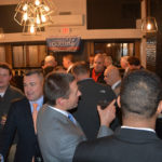 A group of people mingle at an event in support of Anthony Gulluni.