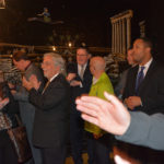 A group of people applauding and talking amongst one another at an event